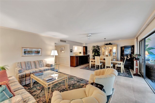 tiled living room featuring ceiling fan and ornamental molding