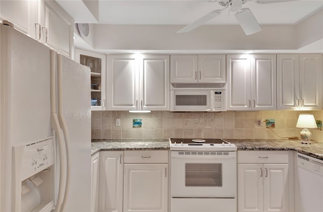 kitchen with decorative backsplash, white appliances, and white cabinetry