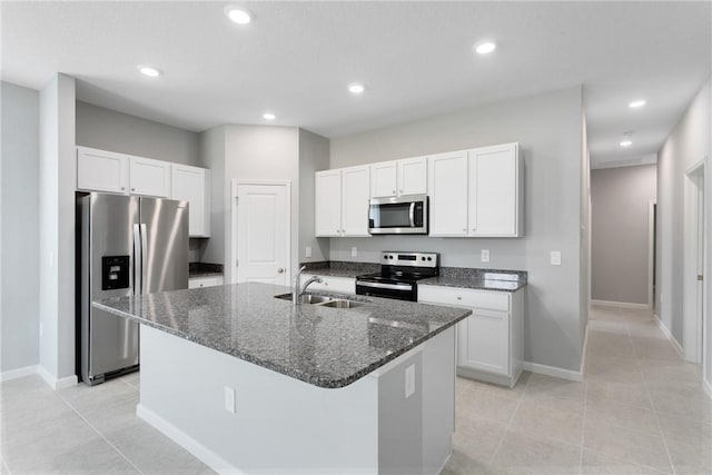 426 Douglas Ct, Fort Pierce, FL 34950 - kitchen with white cabinets, a sink, dark stone counters, a center island with sink, and stainless steel appliances