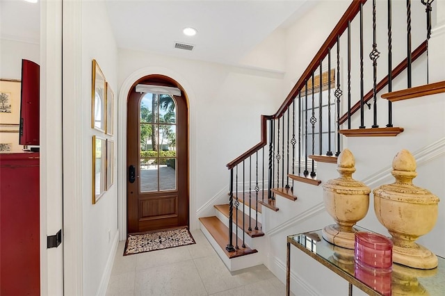 1507 Ocean Dr Unit 5, Vero Beach, FL 32963 - entrance foyer with arched walkways, baseboards, light tile patterned flooring, and stairs
