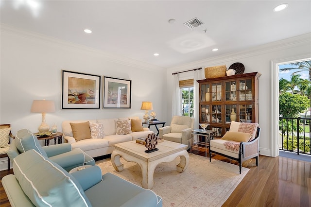 living room with wood-type flooring and ornamental molding