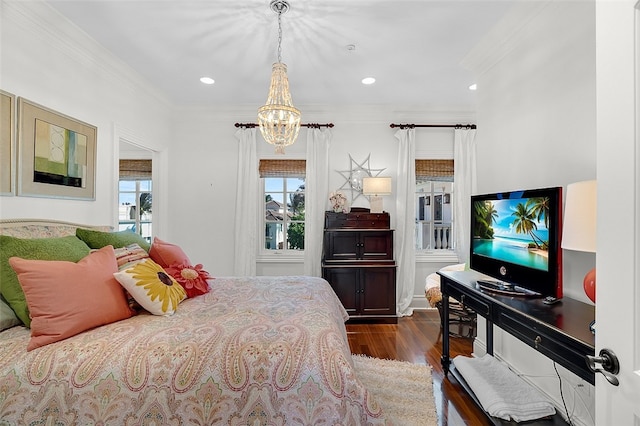 bedroom with dark hardwood / wood-style floors, ornamental molding, and a chandelier