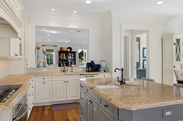 kitchen featuring kitchen peninsula, black electric stovetop, light hardwood / wood-style flooring, and sink