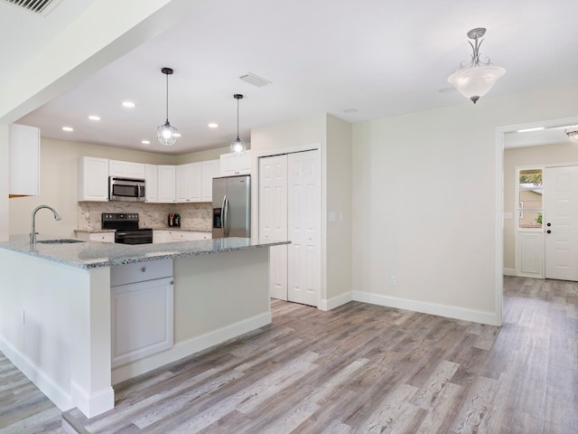 kitchen with stainless steel appliances, pendant lighting, sink, white cabinetry, and light wood-type flooring