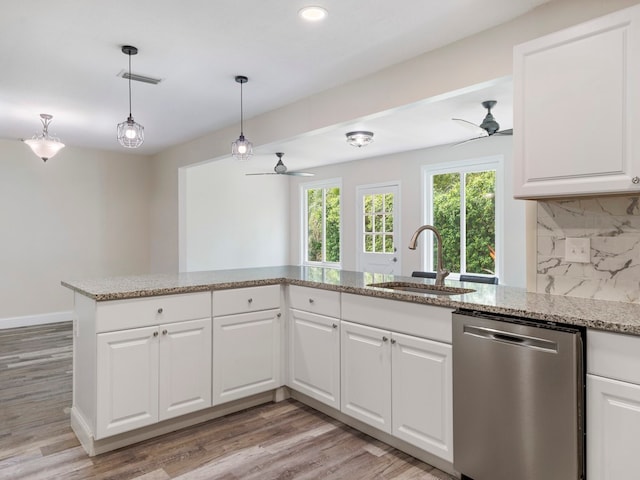 kitchen featuring stainless steel dishwasher, white cabinetry, sink, and light hardwood / wood-style flooring