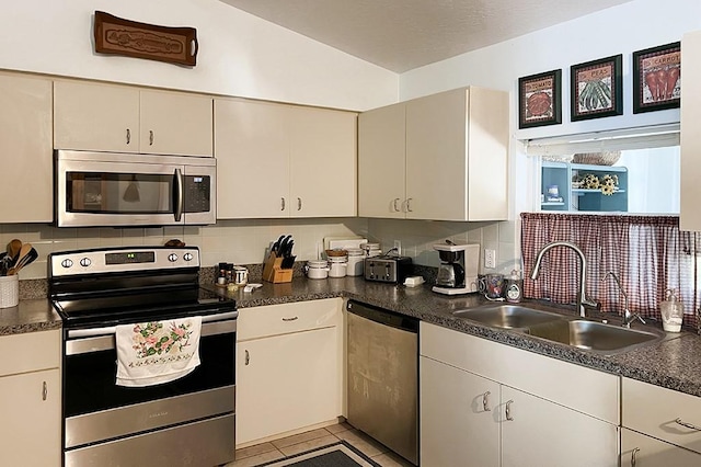 kitchen with sink, backsplash, and appliances with stainless steel finishes