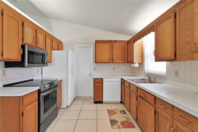 2225 86th Dr, Vero Beach, FL 32966 - kitchen featuring stainless steel appliances, a sink, vaulted ceiling, tasteful backsplash, and light countertops