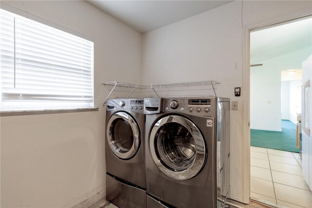 2225 86th Dr, Vero Beach, FL 32966 - laundry area featuring washer and clothes dryer, baseboards, and light tile patterned floors