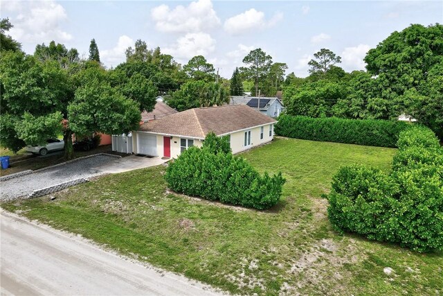 2225 86th Dr, Vero Beach, FL 32966 - ranch-style house featuring gravel driveway, a garage, and a front lawn