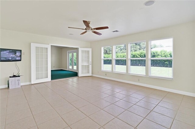 2225 86th Dr, Vero Beach, FL 32966 - spare room with light tile patterned floors, french doors, a ceiling fan, and baseboards