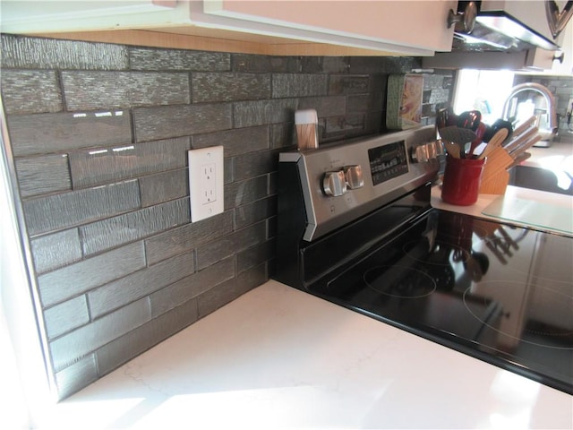 kitchen featuring tasteful backsplash and stainless steel range with electric stovetop