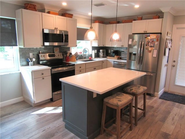 kitchen with white cabinets, a center island, stainless steel appliances, and backsplash