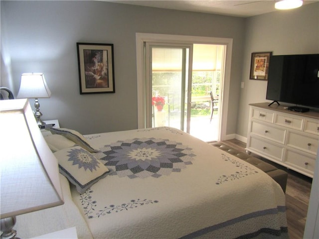 bedroom with access to outside and dark hardwood / wood-style floors