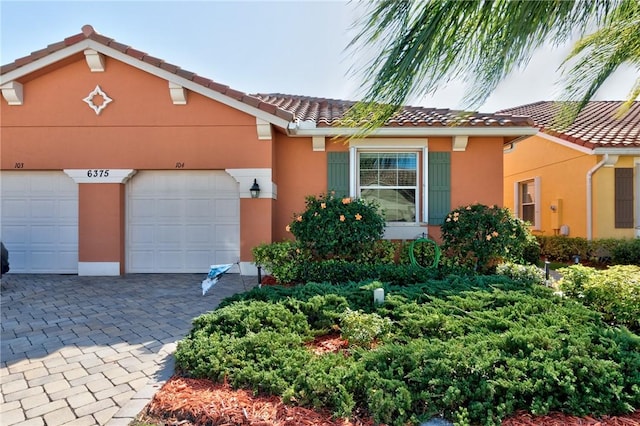 6375 Oxford Cir Unit 104D, Vero Beach, FL 32966 - view of front of house with stucco siding, driveway, and a tile roof