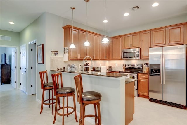 6375 Oxford Cir Unit 104D, Vero Beach, FL 32966 - kitchen featuring tasteful backsplash, visible vents, dark stone countertops, and appliances with stainless steel finishes