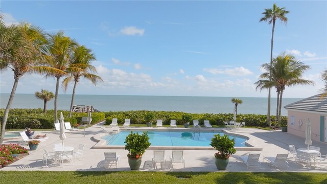 view of pool with a patio and a water view