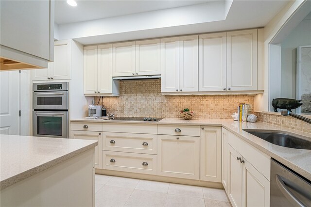 kitchen with stainless steel appliances, light tile patterned flooring, sink, and tasteful backsplash