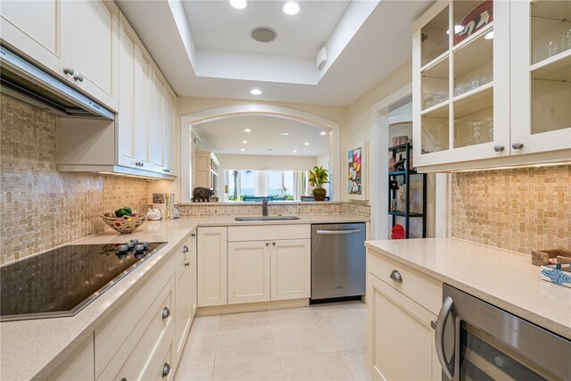 kitchen featuring black electric stovetop, backsplash, a raised ceiling, sink, and dishwasher