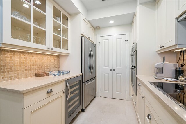 kitchen with appliances with stainless steel finishes, light tile patterned flooring, tasteful backsplash, and wine cooler