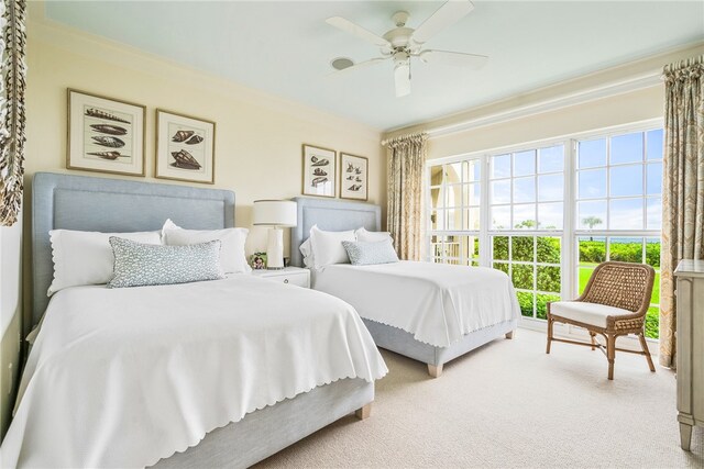 carpeted bedroom featuring ceiling fan and crown molding