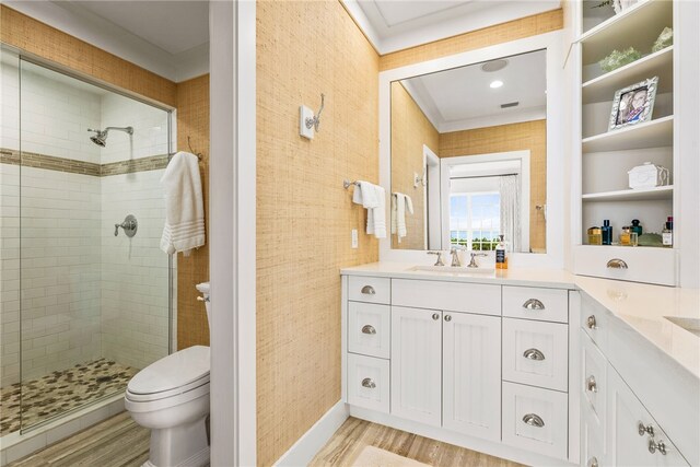 bathroom featuring toilet, vanity, hardwood / wood-style flooring, and a tile shower