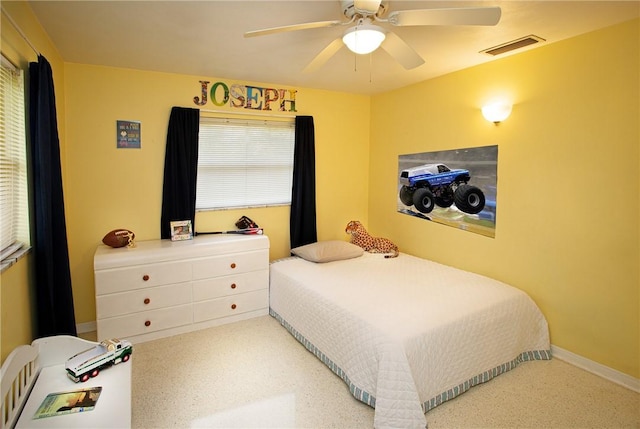 bedroom featuring baseboards, a ceiling fan, and visible vents