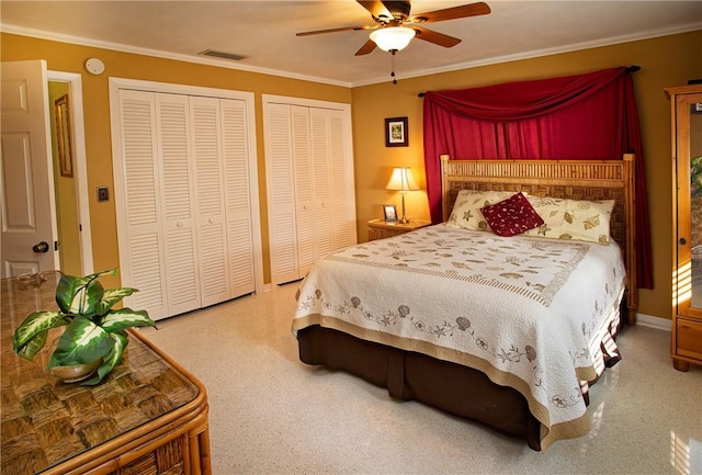 bedroom with visible vents, multiple closets, ornamental molding, and ceiling fan