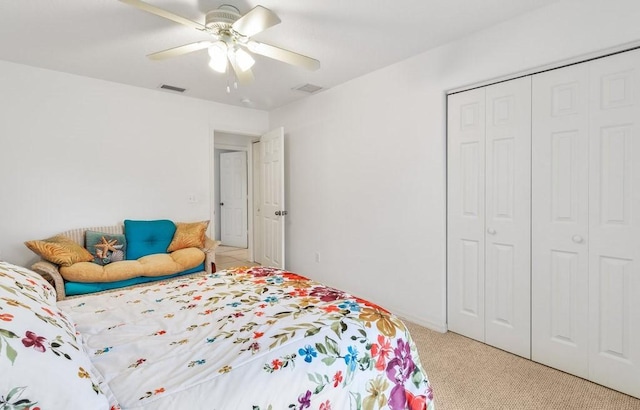 bedroom featuring light colored carpet, a closet, and ceiling fan