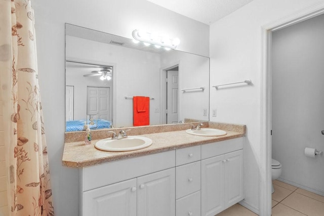 bathroom with tile patterned flooring, vanity, ceiling fan, and toilet