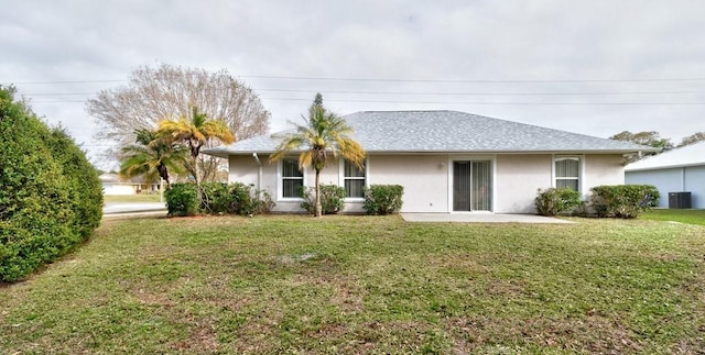 rear view of house with central AC, a lawn, and a patio area