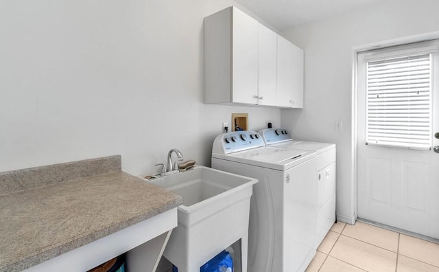 laundry room with cabinets, washer and clothes dryer, sink, and light tile patterned floors