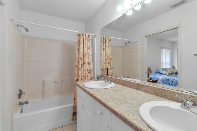 bathroom with tile patterned flooring, shower / bath combo, and vanity