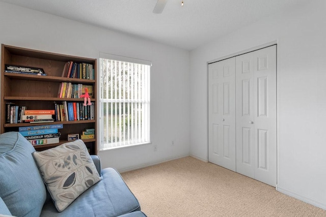 sitting room with a wealth of natural light, light colored carpet, and ceiling fan