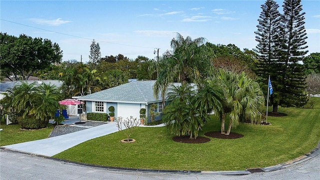 ranch-style house featuring concrete driveway and a front yard