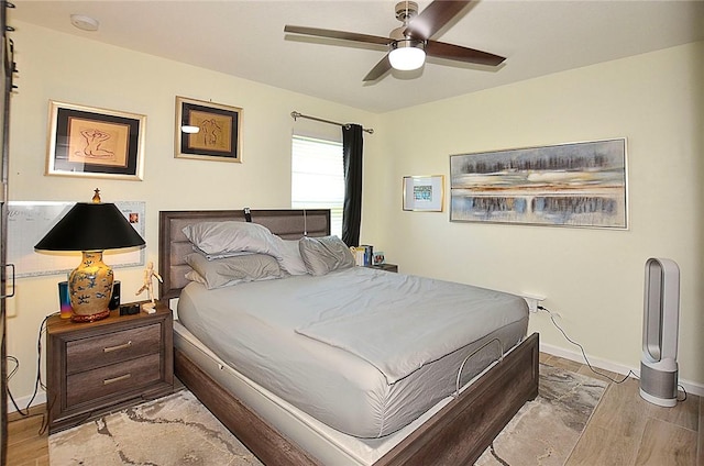 bedroom featuring wood finished floors, baseboards, and ceiling fan