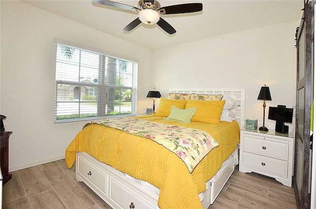 bedroom with wood finish floors, ceiling fan, and baseboards