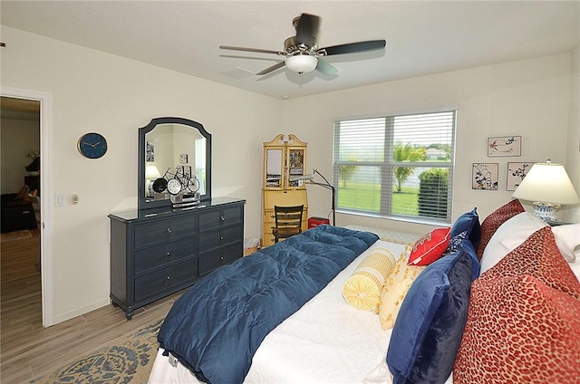 bedroom with light wood-style flooring, ceiling fan, and baseboards