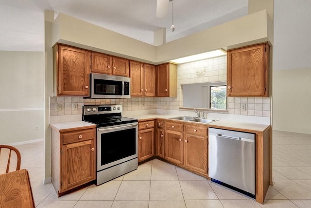 kitchen with ceiling fan, sink, stainless steel appliances, tasteful backsplash, and light tile patterned floors