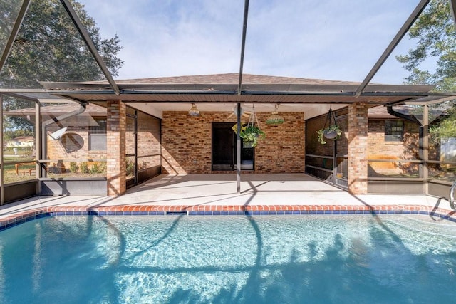 view of swimming pool featuring glass enclosure and a patio