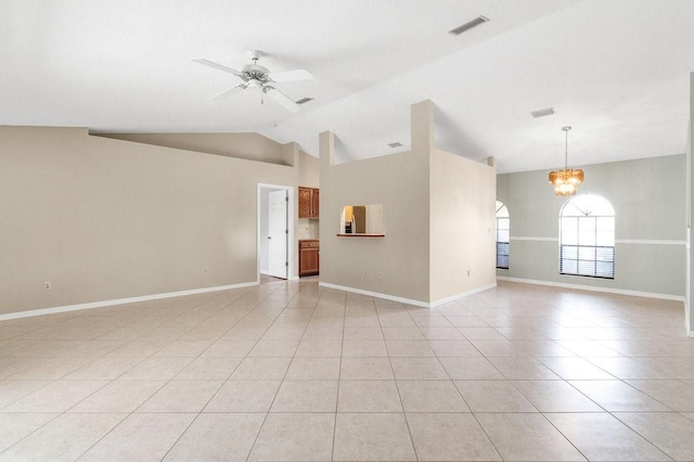 tiled spare room with ceiling fan with notable chandelier and vaulted ceiling