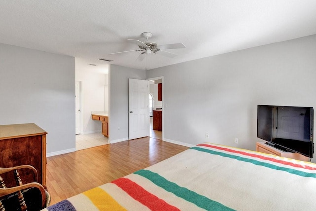 bedroom with light wood-type flooring, ensuite bath, and ceiling fan