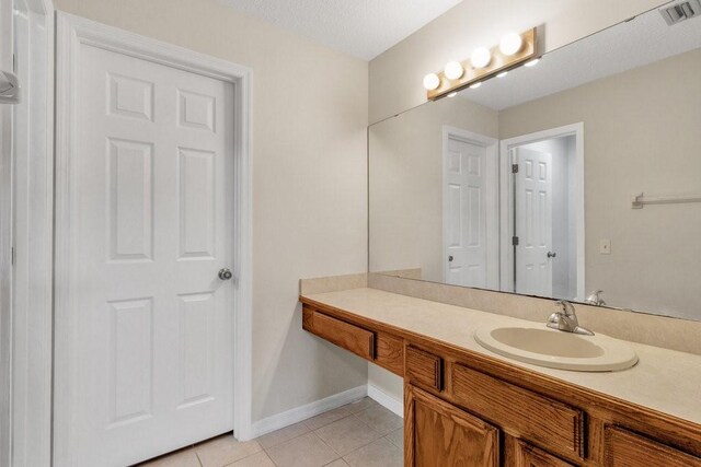 bathroom featuring tile patterned floors, vanity, and a textured ceiling