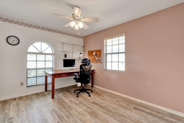 home office with ceiling fan and light hardwood / wood-style flooring