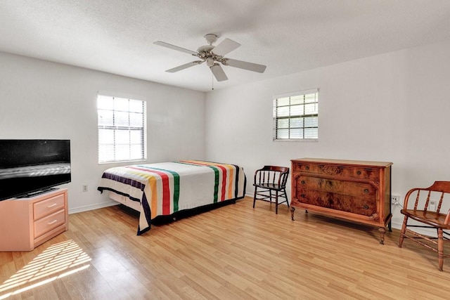 bedroom featuring ceiling fan, a textured ceiling, and light hardwood / wood-style flooring