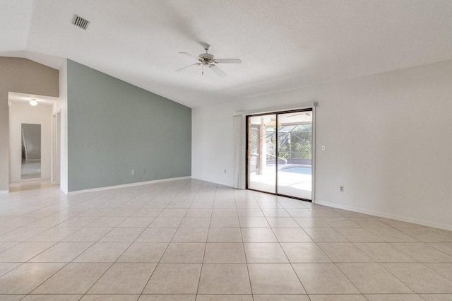 tiled empty room featuring a textured ceiling, ceiling fan, and lofted ceiling