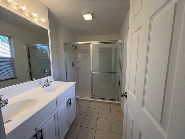 bathroom with tile patterned flooring, a shower with shower door, and a textured ceiling