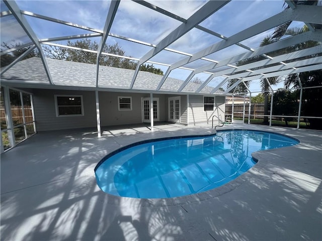 view of swimming pool with glass enclosure, a patio area, and french doors