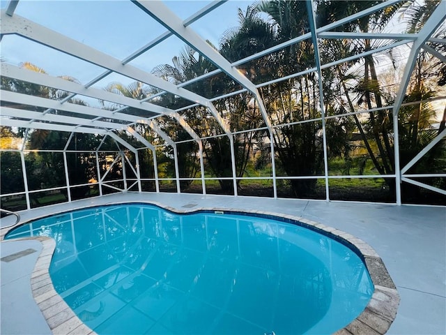 view of pool with glass enclosure and a patio area