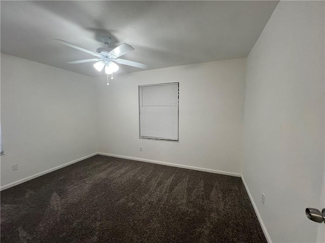 spare room with ceiling fan and dark carpet