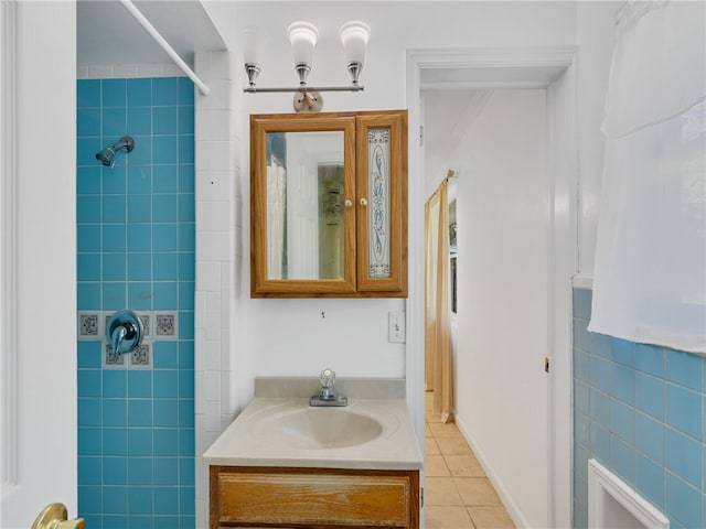 bathroom with vanity, tile patterned flooring, tile walls, and a tile shower